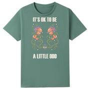 A slate green oversized tee with the It's OK To Be A Little Odd graphic printed large on the front.