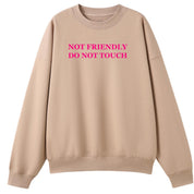 A peach oversized crew neck with the Not Friendly Do Not Touch graphic printed large on the front.