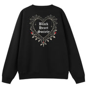 A black oversized crew neck shown from the back, with the Black Heart Society graphic printed large across the back.