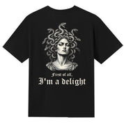 A black V-neck oversized tee shown from the back, with the First Of All I'm A Delight graphic printed large across the back.