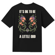 A black V-neck oversized tee shown from the back, with the It's OK To Be A Little Odd graphic printed large across the back.