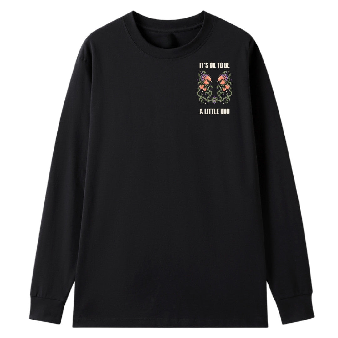 A black oversized long sleeve tee with a small It's OK To Be A Little Odd graphic on the left chest.