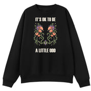 A black oversized crew neck with the It's OK To Be A Little Odd graphic printed large on the front.