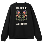 A black oversized crew neck shown from the back, with the It's OK To Be A Little Odd graphic printed large across the back.