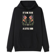 A black oversized hoodie with the It's OK To Be A Little Odd graphic printed large on the front.