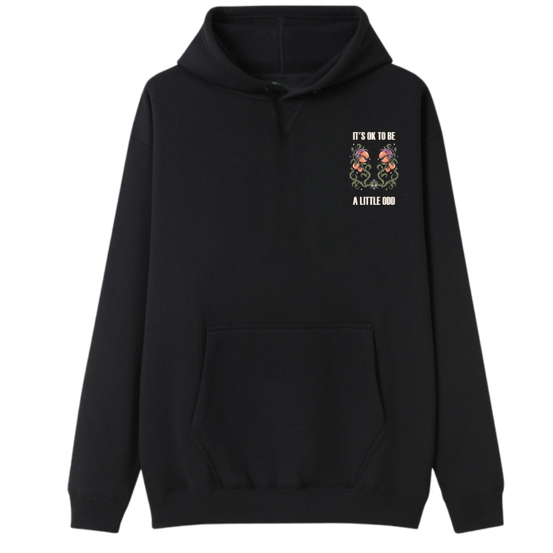 A black oversized hoodie with a small It's OK To Be A Little Odd graphic on the left chest.