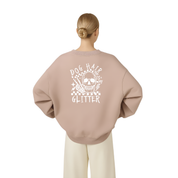 A woman viewed from behind wearing a dusty pink sweatshirt with a white graphic on the back that reads 'DOG HAIR IS MY GLITTER' around a skull design, paired with cream pants against a plain white background.