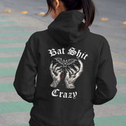 Person wearing a black hoodie with graphic design and text on the back.