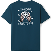A dark teal blue short-sleeve t-shirt shown from the back, featuring a graphic print of two skeletal hands holding a skull with the text 'SUMMONING A FUCK TO GIVE' and small white bats.