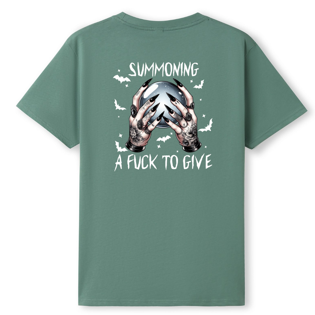 A sage green short-sleeve t-shirt shown from the back, featuring a graphic of tattooed hands holding a silver skull with the text 'SUMMONING' above and 'A FUCK TO GIVE' below.