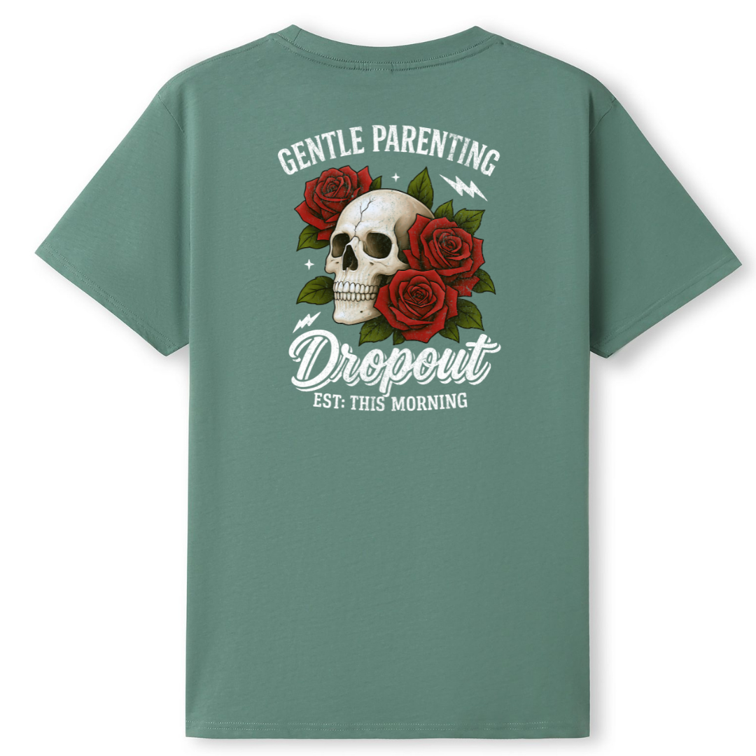 A sage green short-sleeve t-shirt shown from the back, featuring a graphic print of a skull surrounded by red roses and the text 'GENTLE PARENTING The Dropout EST. THIS MORNING'.