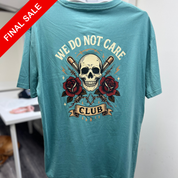 Teal t-shirt with skull and roses design and 'We Do Not Care Club' text on a white background.