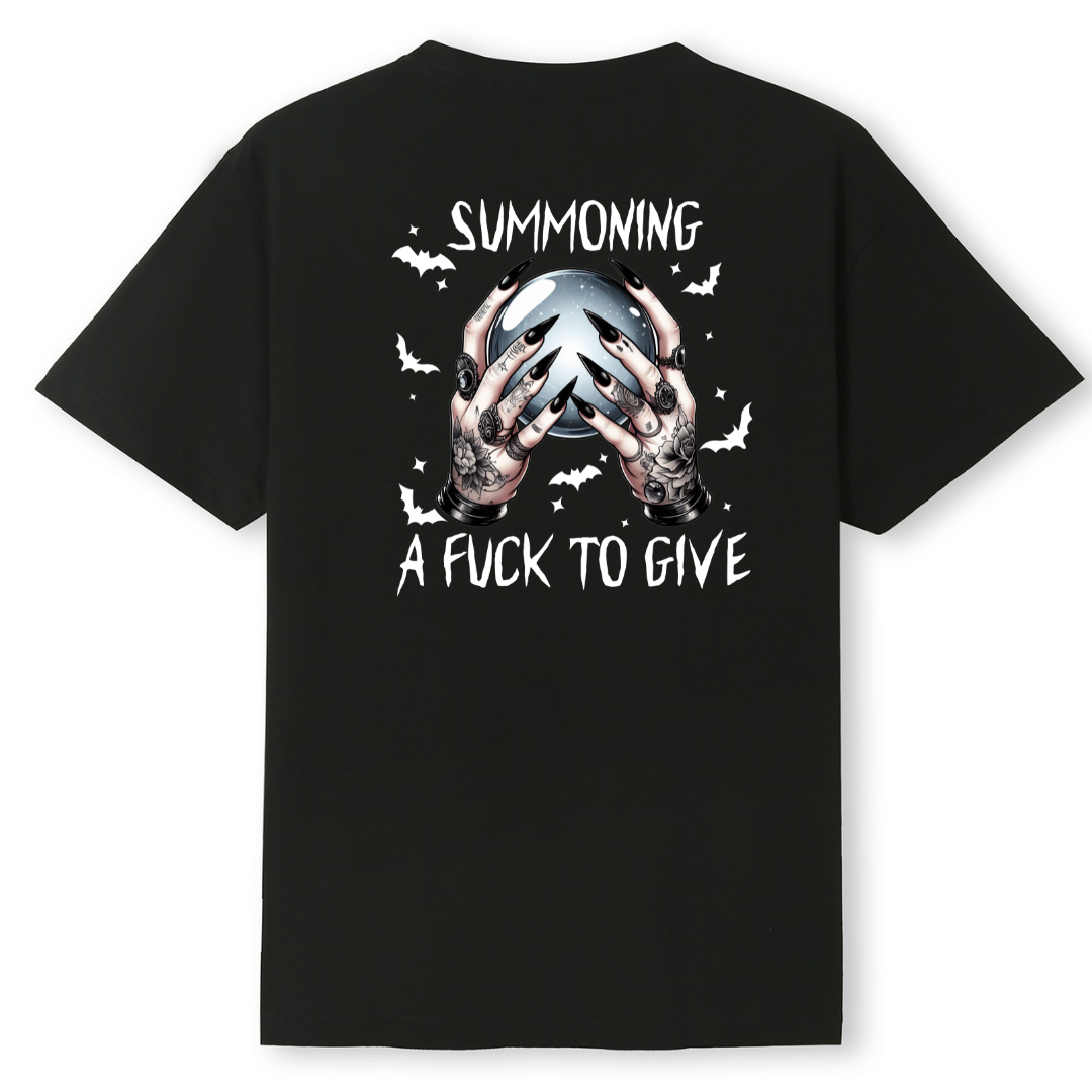 A black short-sleeve t-shirt with a graphic on the back featuring a skull, hands, bats, and white text reading 'SUMMONING A FUCK TO GIVE'.
