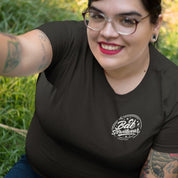 Person wearing a black t-shirt with a logo outdoors