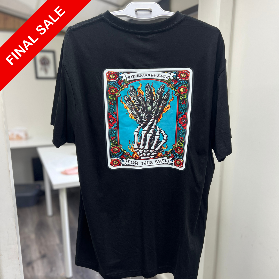 Black t-shirt with a colorful graphic design on a hanger against a white wall.