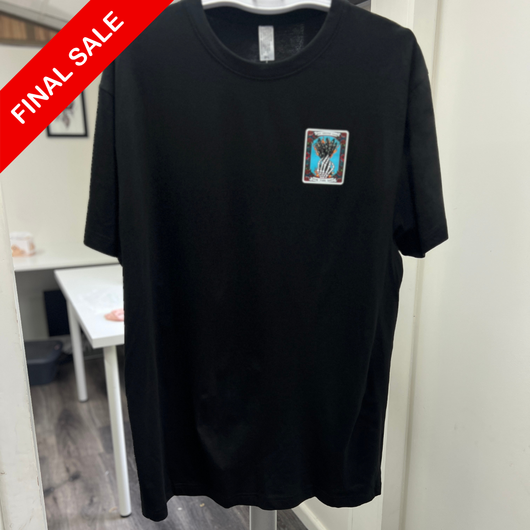Black t-shirt with a small graphic on a hanger in a room.