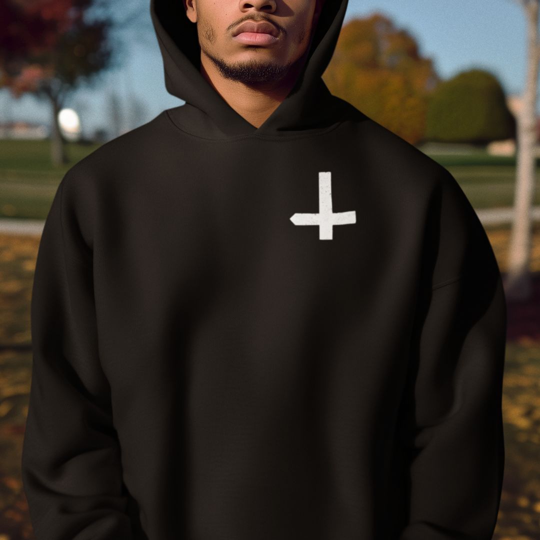 Person wearing a black hoodie with a white symbol outdoors