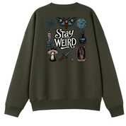 An olive green crewneck sweatshirt featuring a detailed graphic print on the back with occult-themed illustrations and the text 'Stay WEIRD'.