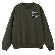 An olive green crewneck sweatshirt with a white graphic text print reading 'Stay WEIRD' on the left chest, displayed against a solid white background.