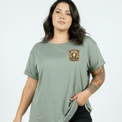 Woman wearing a green t-shirt with a logo on a plain background