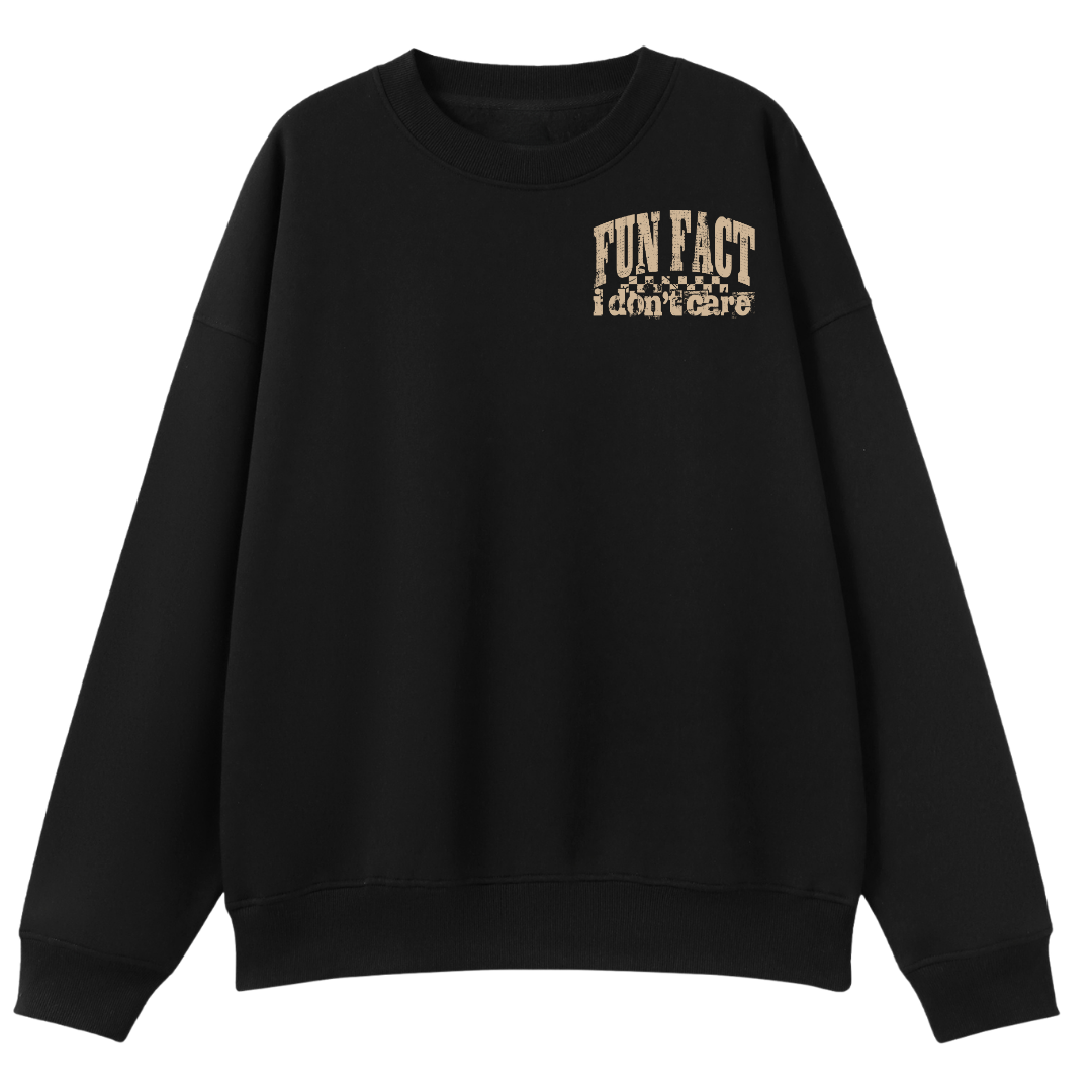 A black crewneck sweatshirt with a distressed beige graphic on the left chest that reads 'FUN FACT i don't care' with a small checkered pattern, shown against a plain white background.