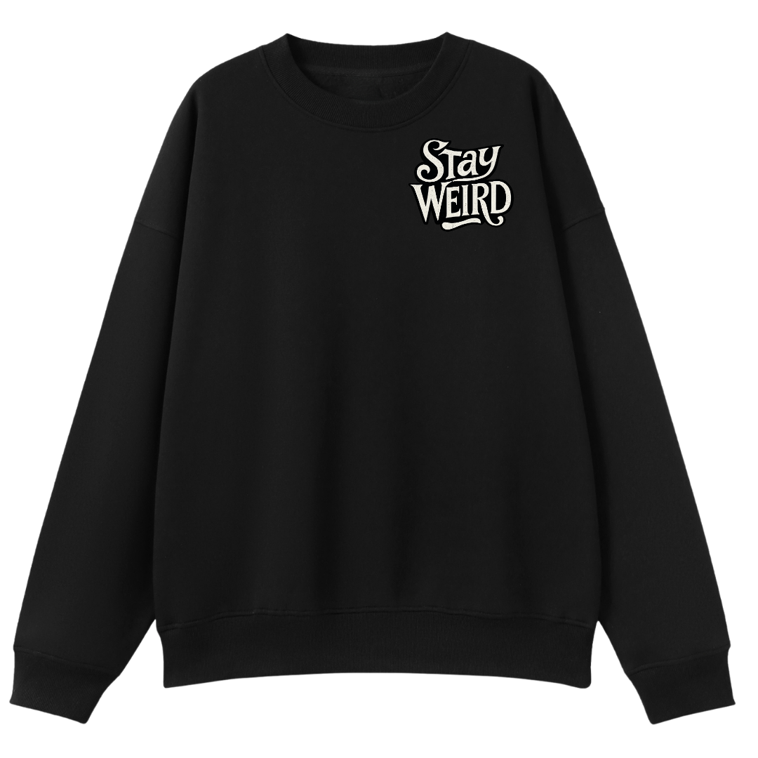 A black crewneck sweatshirt with a white graphic text print reading 'Stay Weird' on the left chest, displayed against a solid white background.