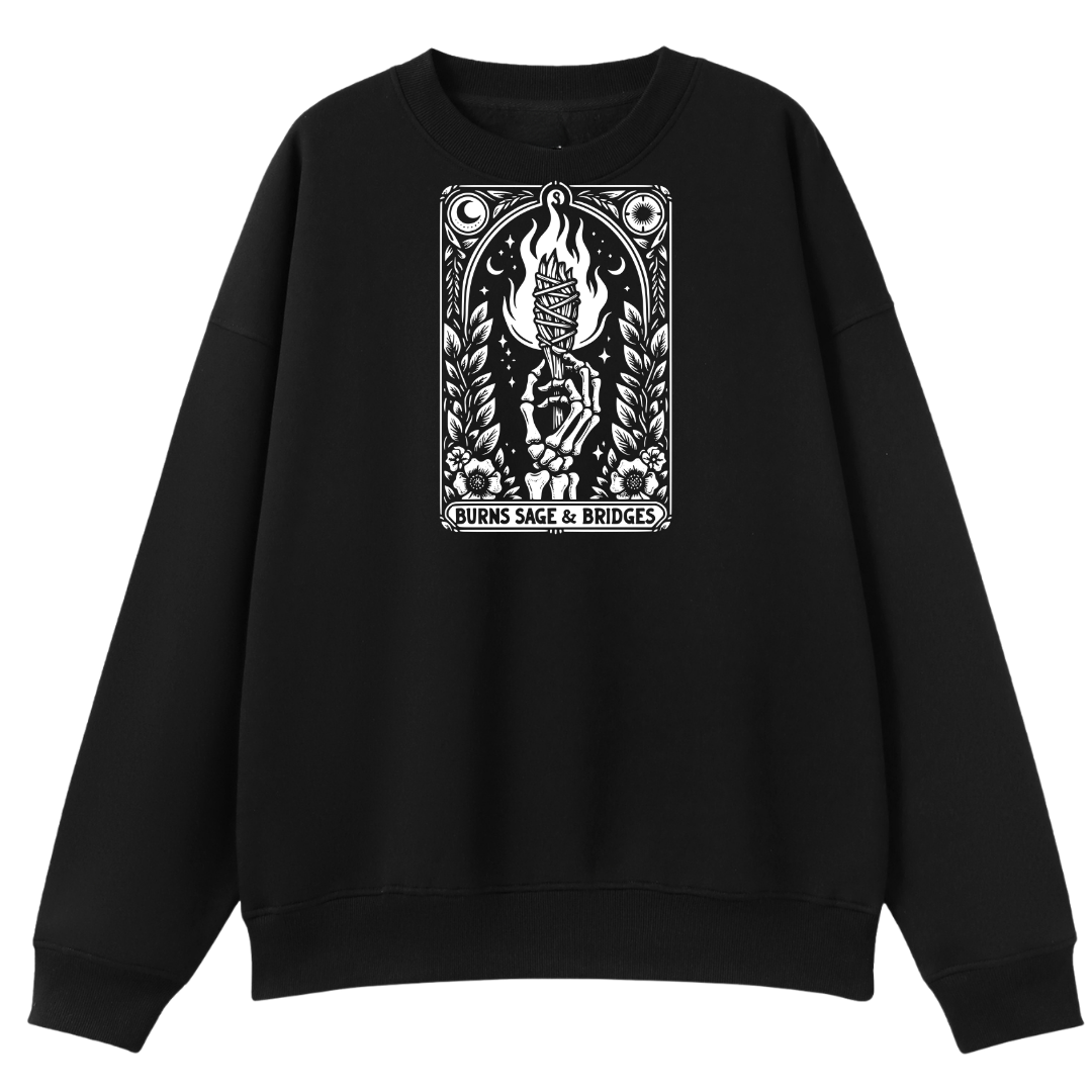 A black crewneck sweatshirt featuring a prominent white graphic print on the chest depicting a tarot card illustration with the text 'BURNS SAGE & BRIDGES'.