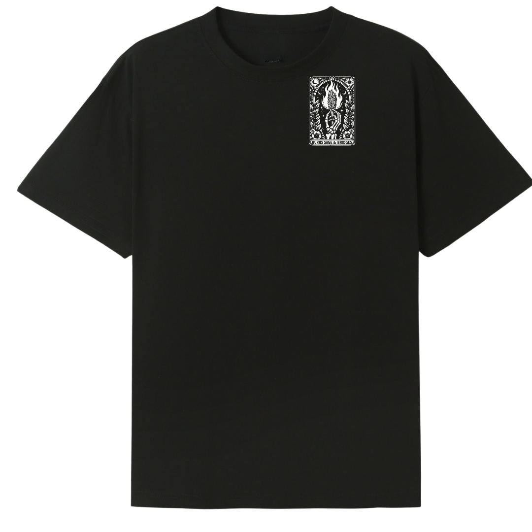 A black short-sleeve crewneck t-shirt featuring a small white graphic print on the left chest with a stylized face and the text 'THE GODDESS'.