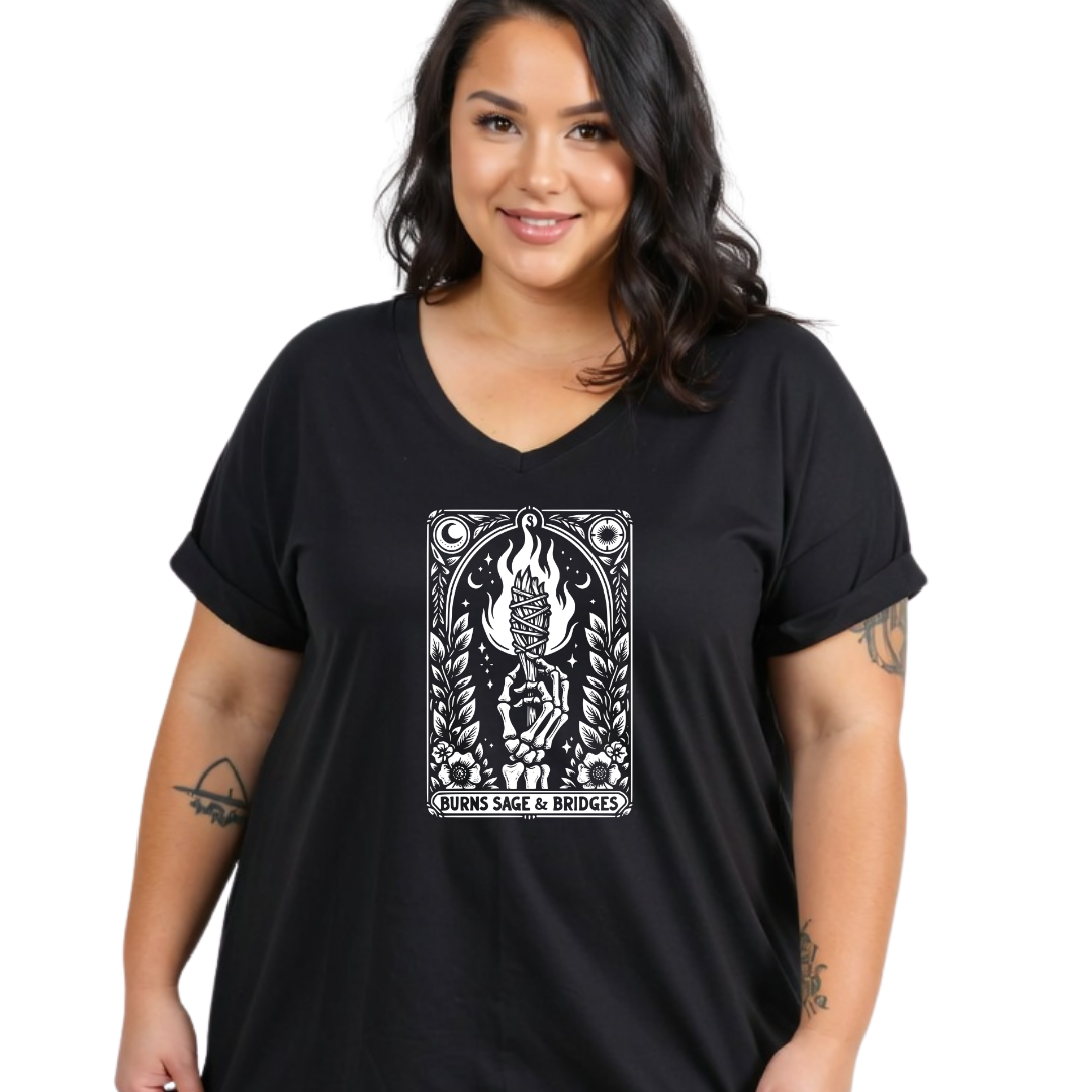 A woman wearing a black V-neck t-shirt with a white tarot card graphic on the chest. The graphic depicts a hand holding a sword with flames and the text 'RUNES Sage & BRIDGES'.