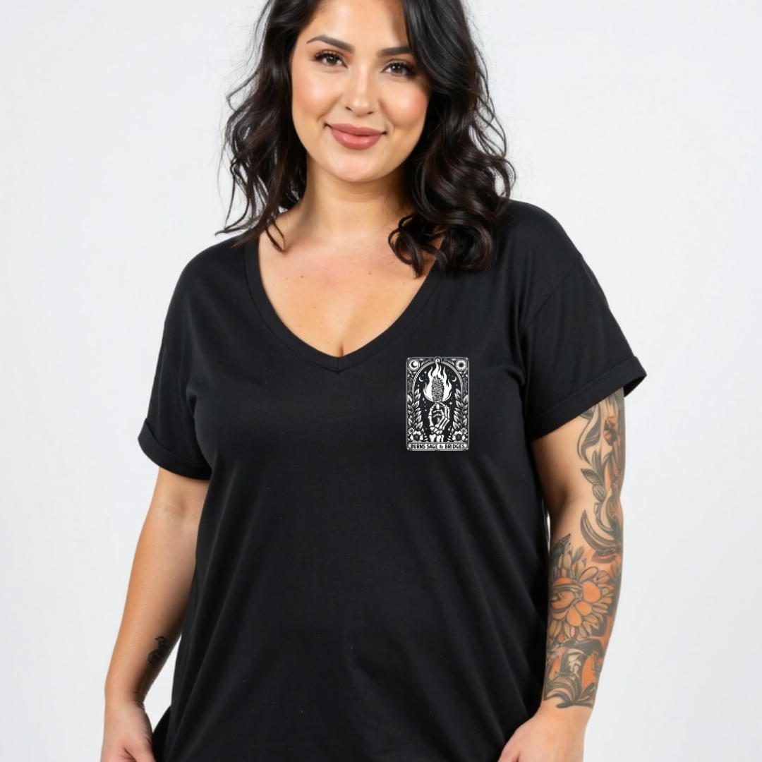A woman wearing a black V-neck t-shirt with a white graphic print on the left chest, photographed against a plain light gray background.