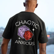 Person wearing a black t-shirt with 'Chaotic Anxious' design featuring polyhedral dice.