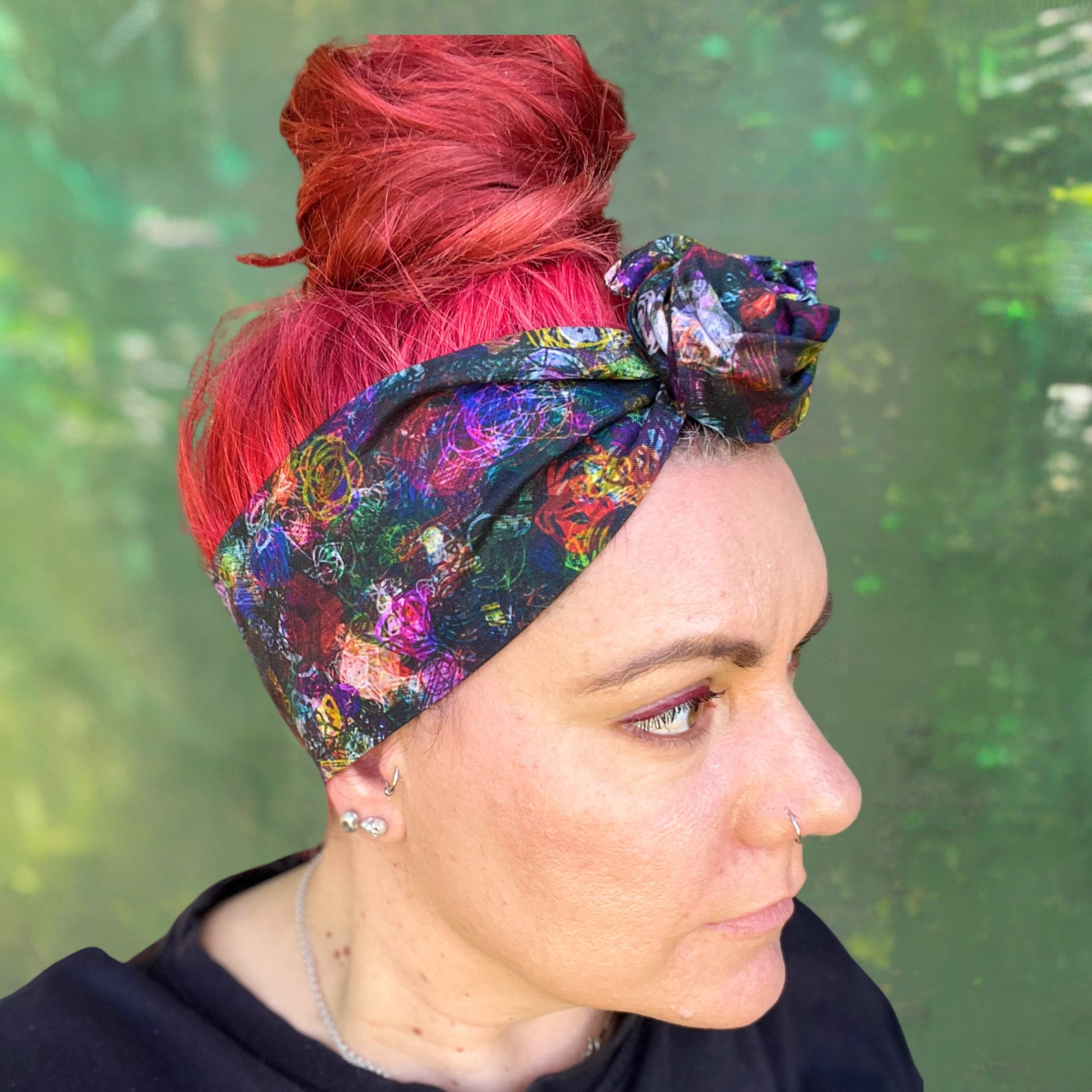 a colorful wire headwrap with a vibrant, abstract pattern. The headwrap is tied at the top, giving it a playful and chic bow effect.