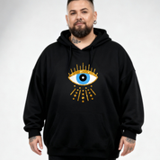 Person wearing a black hoodie with a unique design on a plain background