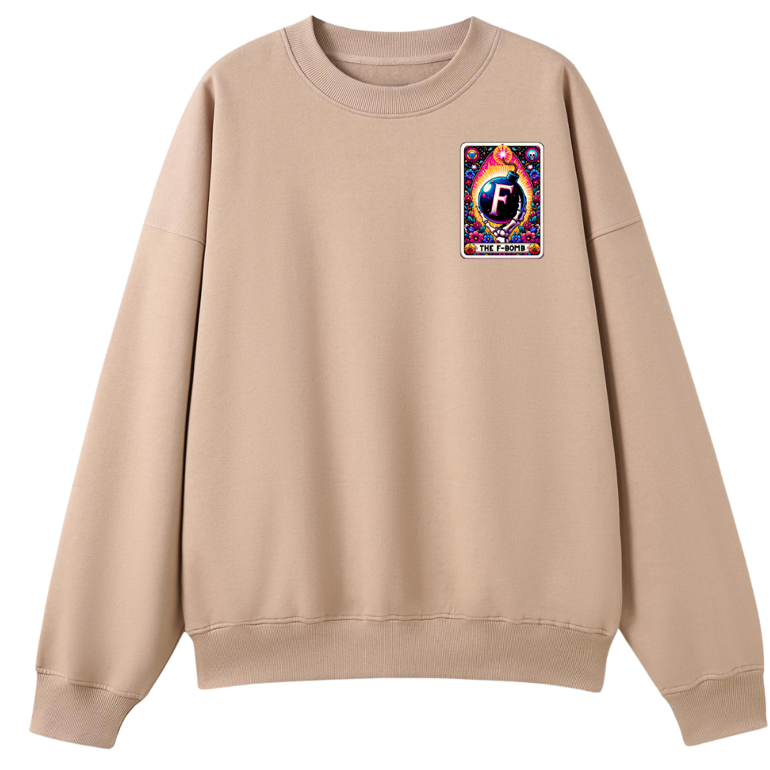 A beige crewneck sweatshirt with a colorful graphic patch on the left chest featuring a stylized letter 'F' and the text 'FASHION IS FLOWING'.