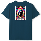 A dark teal blue t-shirt with a colorful graphic print on the chest. The graphic is styled like a tarot card titled 'THE F-BOMB', featuring a central black sphere with a white 'F' and a colorful cosmic and floral design.