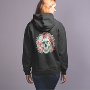 Black hoodie with a floral skull design on the back, worn by a person against a gray background