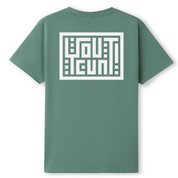 A sage green short-sleeve t-shirt shown from the back, featuring a large white geometric graphic with the word 'OUTCAST' in stylized block letters inside a white rectangular border.