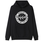 A black pullover hoodie with a white circular graphic on the chest that reads 'WHISPER WIFE TO myself LIKE 20 TIMES EVERY DAY'.