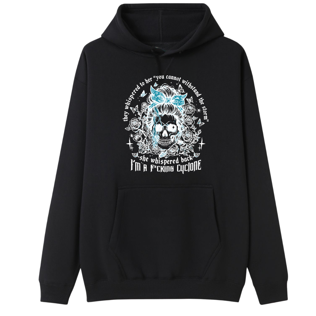 A black pullover hoodie with a front graphic of a skull with blue hair, surrounded by text and floral details, displayed on a solid white background.