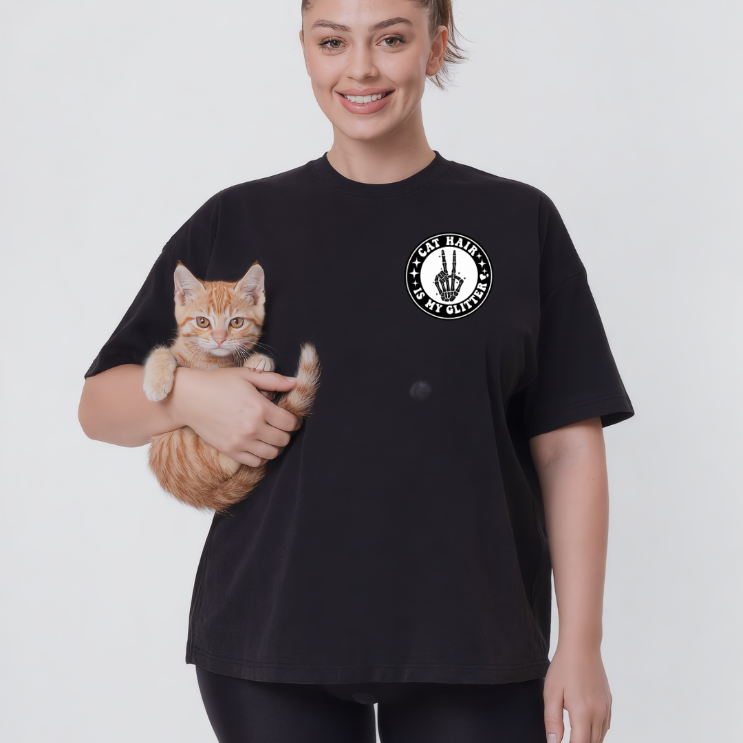 Person wearing a black t-shirt with a cat graphic and text, holding a cat.