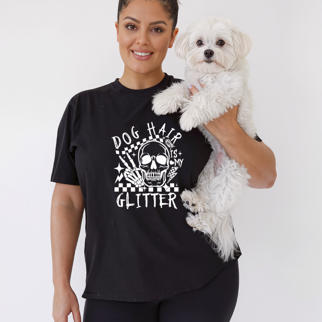 Woman wearing a black t-shirt with a skull design and text, holding a white dog.