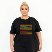 Person wearing a black t-shirt with colorful geometric pattern on a white background