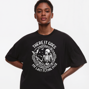 Person wearing a black t-shirt with a graphic design and text on a plain background