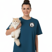 Woman holding a cat wearing a blue t-shirt with a logo on a white background