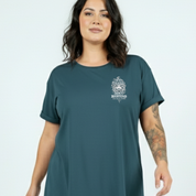 Woman wearing a teal t-shirt with a white graphic design on a light blue background