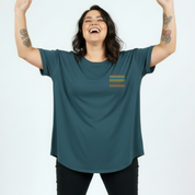 Person wearing a teal t-shirt with a colorful pocket design on a white background