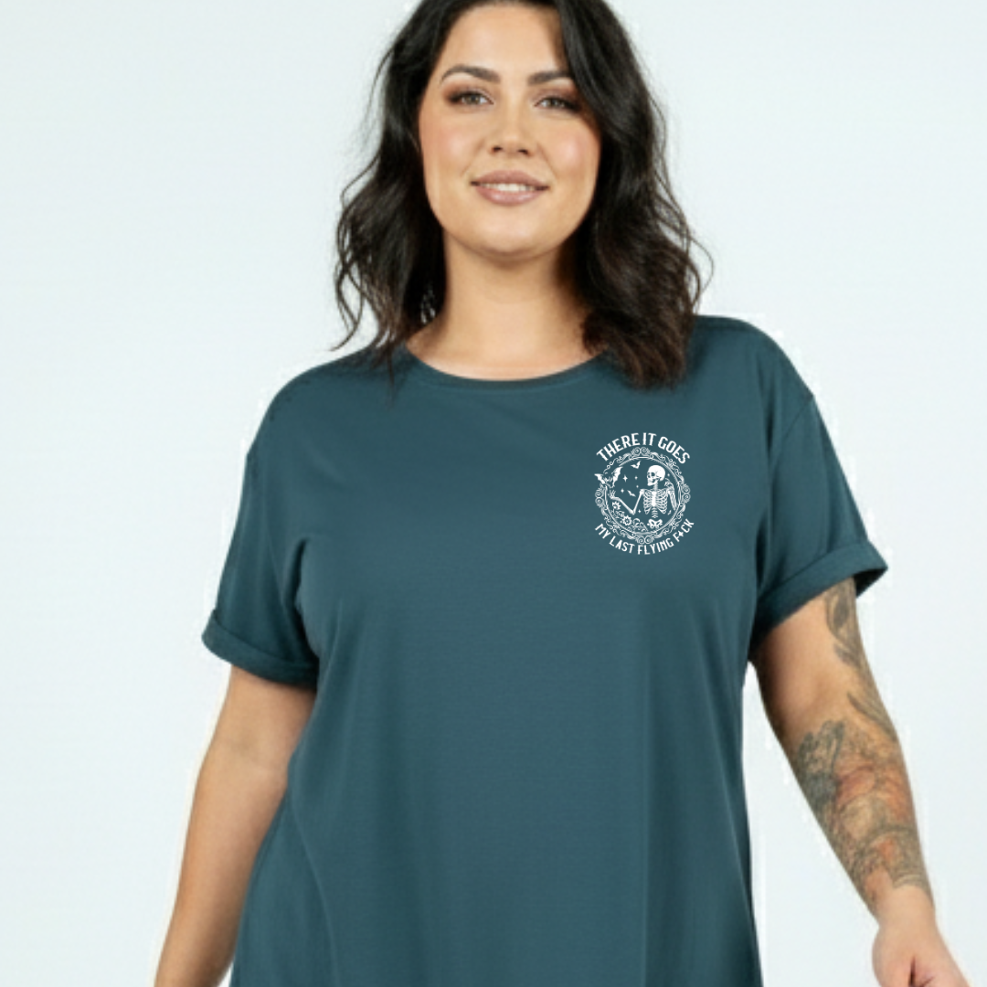 Woman wearing a teal t-shirt with a graphic design on a light gray background