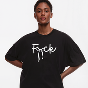A model wearing an oversized black t-shirt with the word 'Fuck' printed in white script across the chest, set against a plain light gray background.