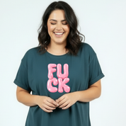 Woman wearing a teal t-shirt with pink text on a plain background