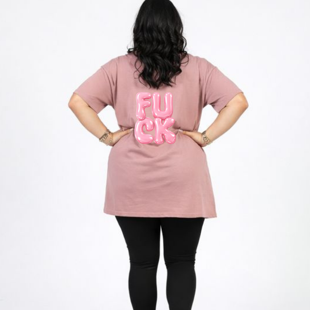 Person wearing a pink t-shirt with 'FU**K' printed on the back against a white background